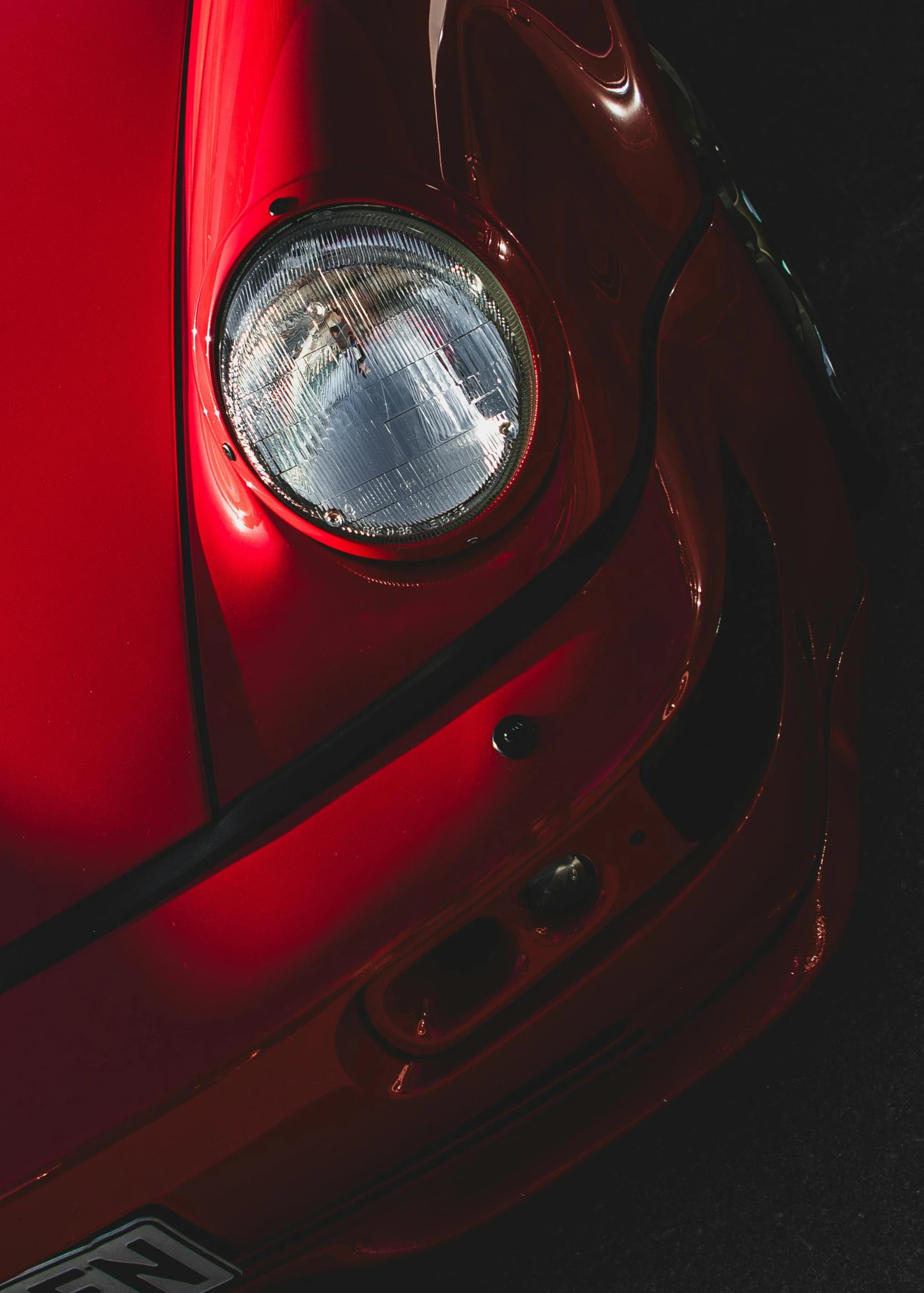 closeup s of the front lights on the red sports car