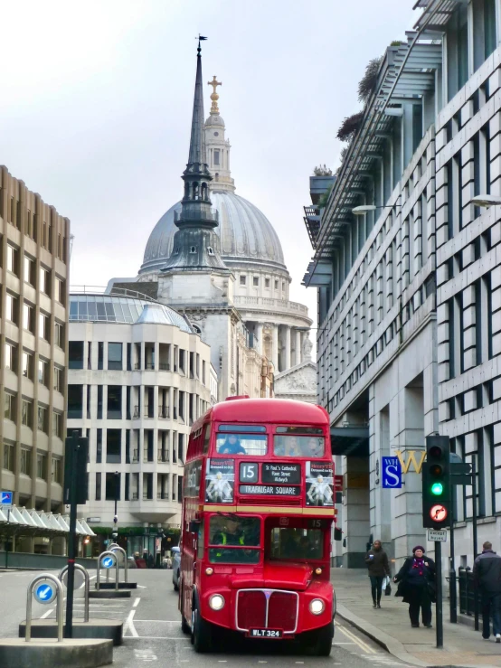 red double decker bus passing over bridge to other buildings