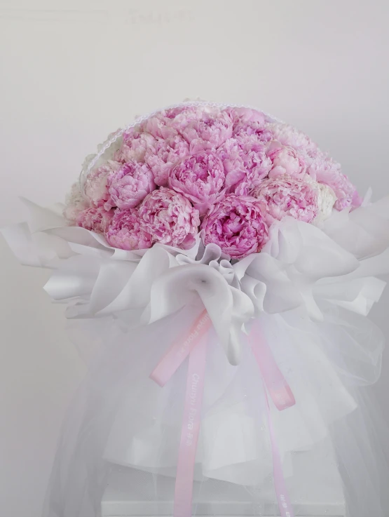 a bouquet with pink flowers in a white tulle bag