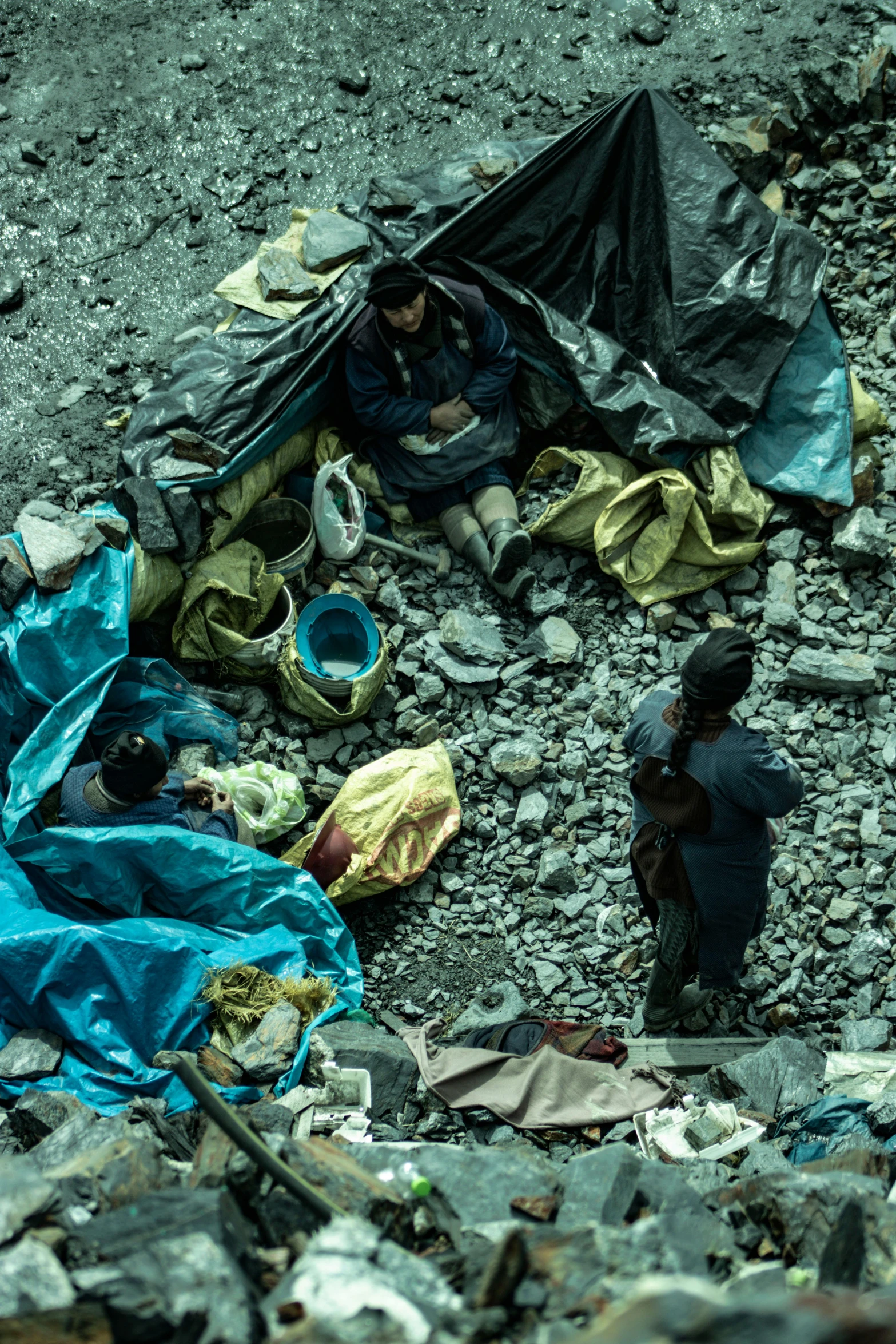 people sitting and standing near many debris on the ground