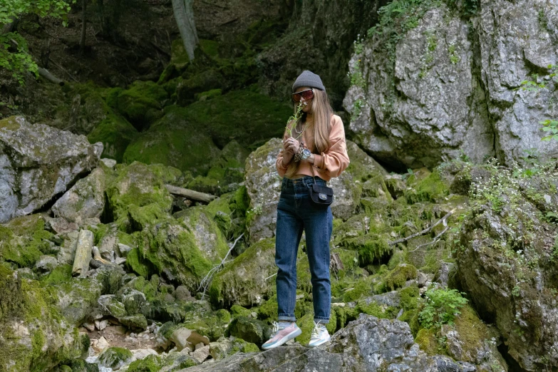 a woman standing on a rock in the forest