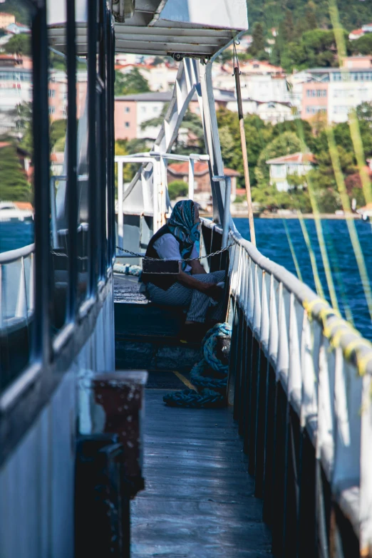 a man sits in the dock on a boat looking at his cell phone