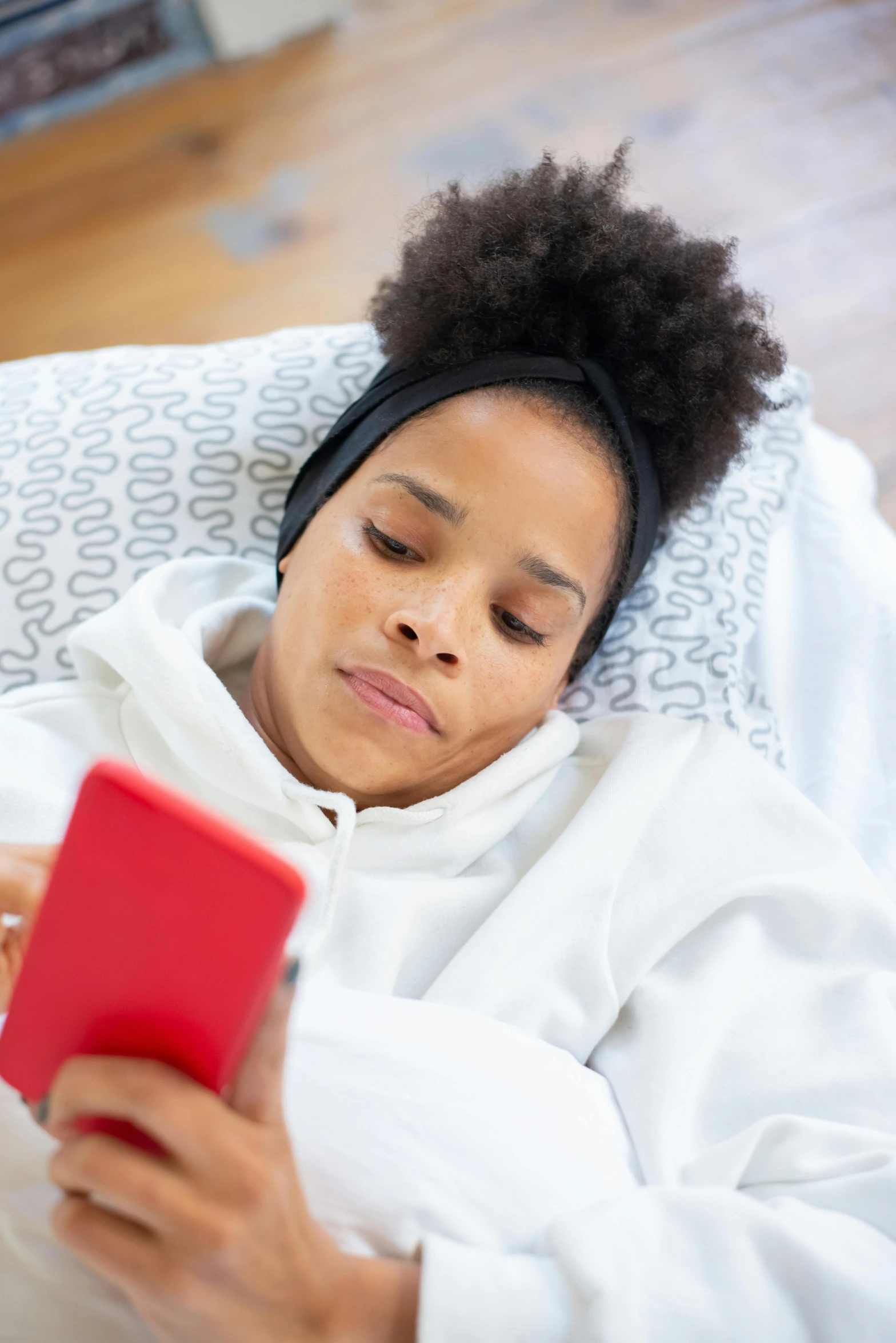 a woman laying in bed holding an mp3 player