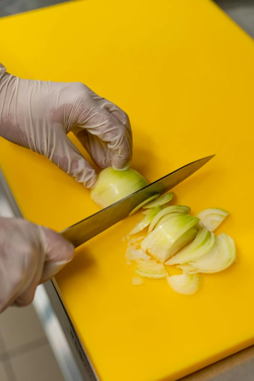 person wearing a white glove  up an onion