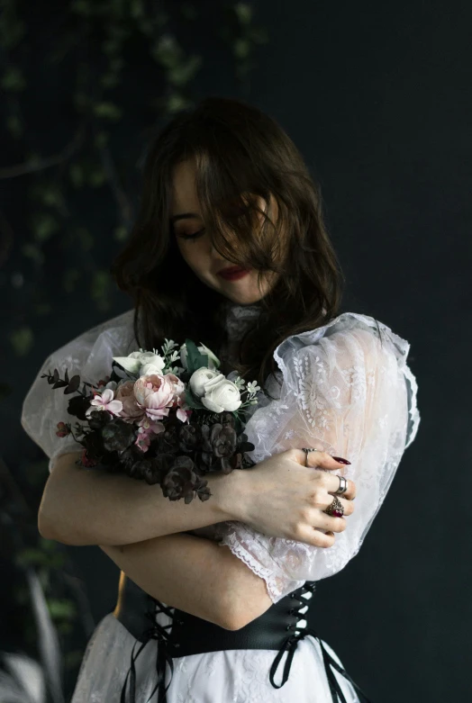 a woman in white dress holding a bouquet of flowers