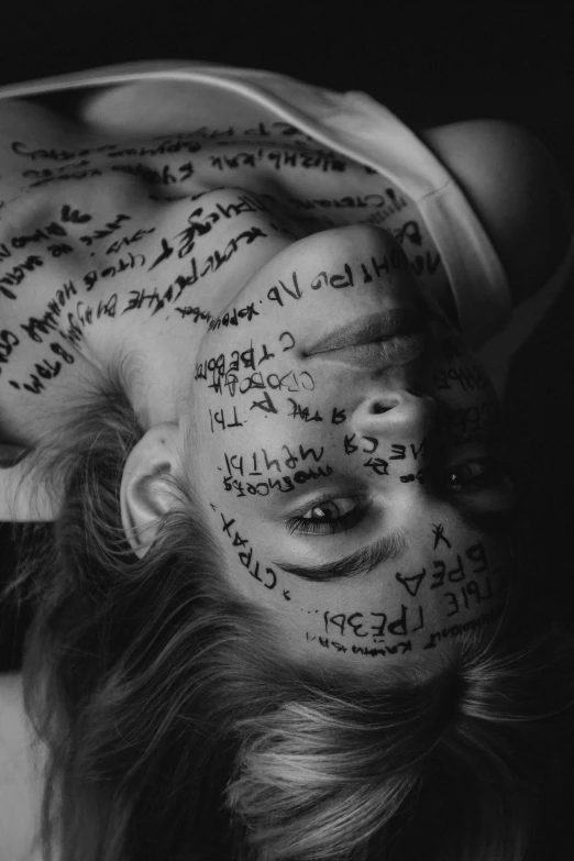 a woman has her hair tied up and has writing all over her face