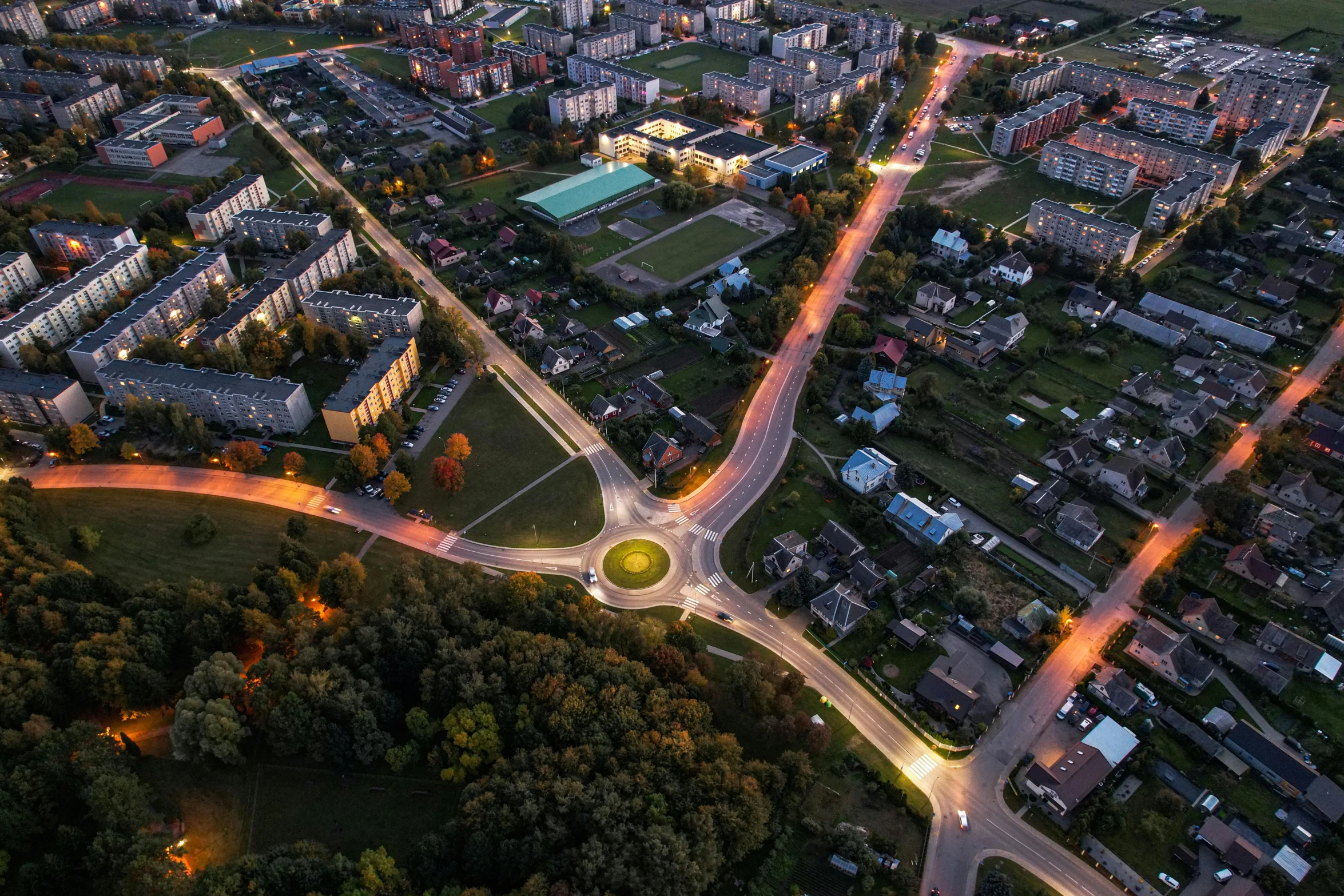 a aerial view of a city with several streets, cars, and lots of trees