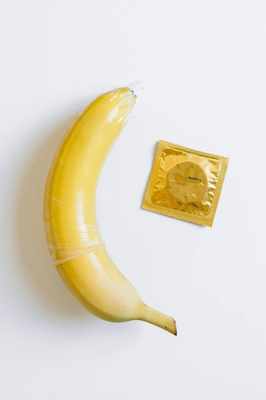 the small banana is next to a gold snack