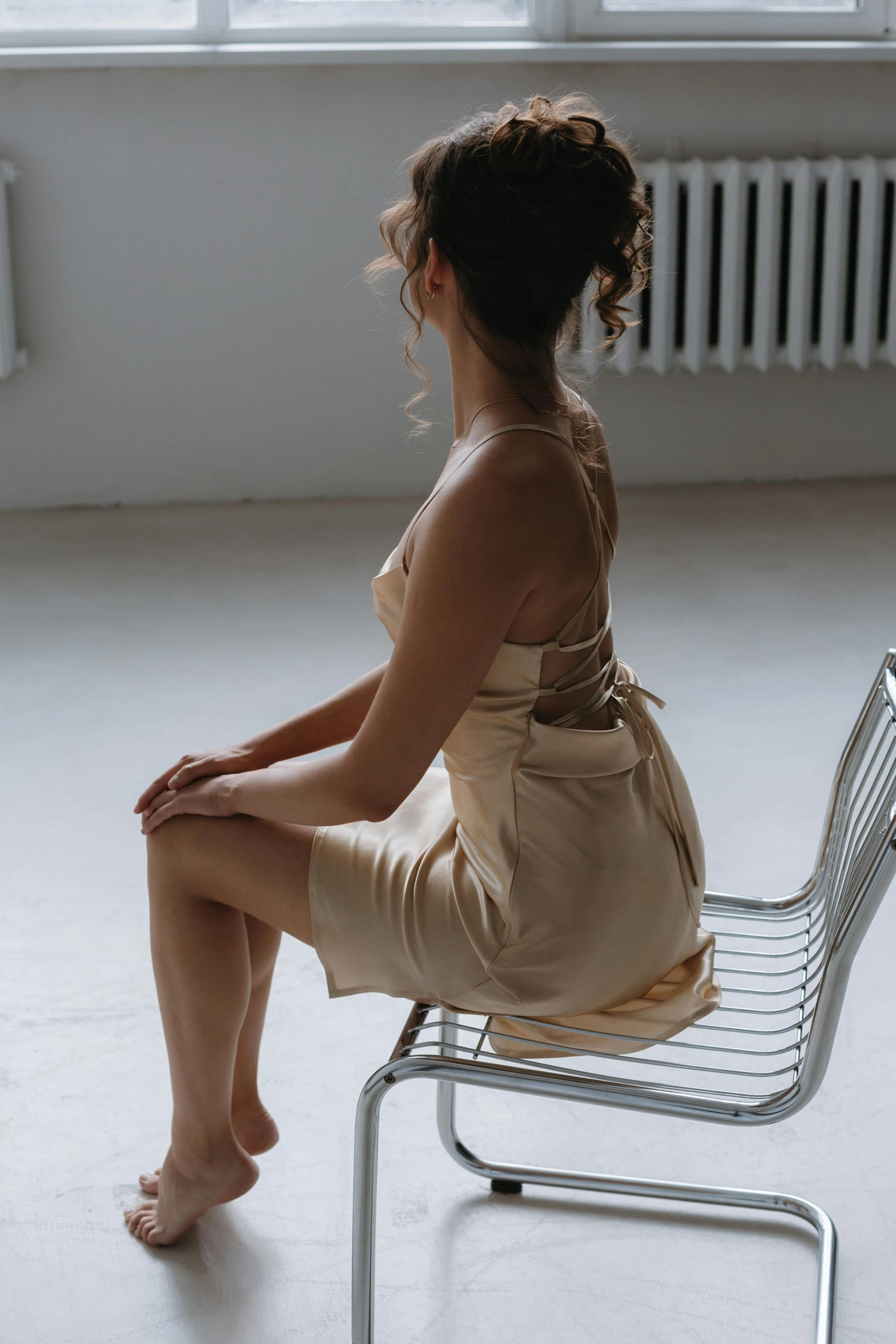 a lady sitting in a chair with a hand bag on her shoulders