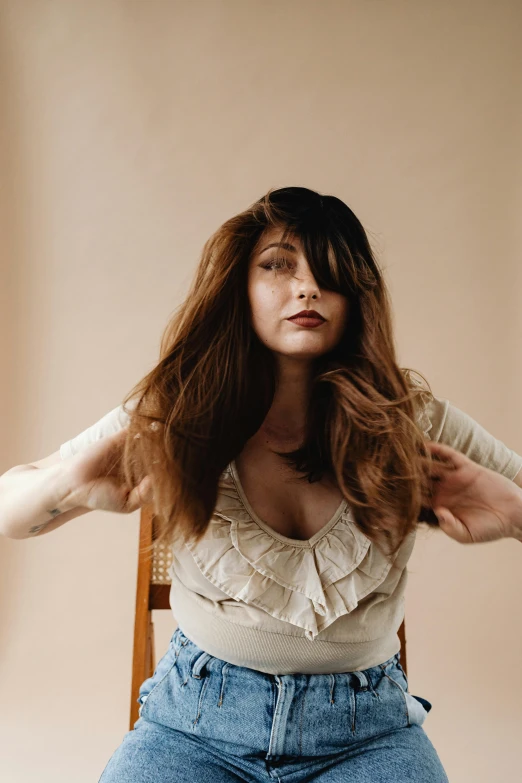 a woman sitting on a chair holding her arms up