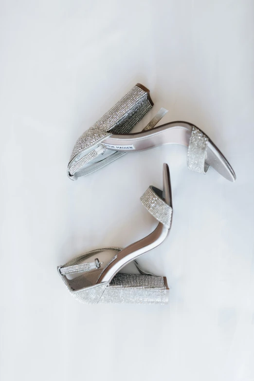 four silver womens shoes that are laying down on the ground