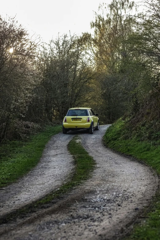 a car is parked on a narrow dirt road