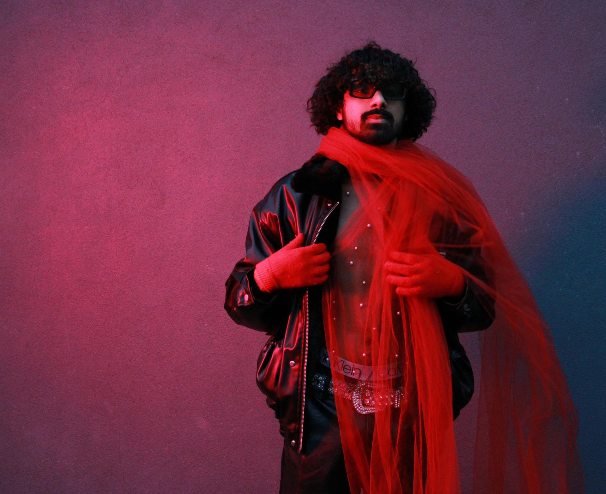 a man wearing a leather jacket and red veil posing for a po