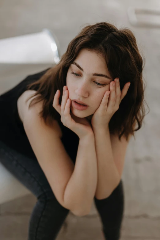 there is a woman that is kneeling down touching her head