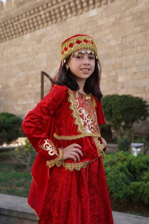 a  in a red and gold costume smiles at the camera