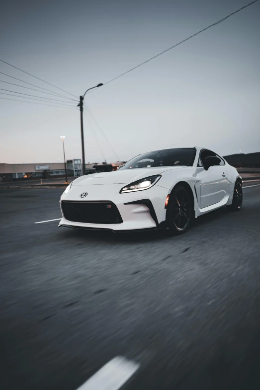 a white toyota sports car driving down the highway