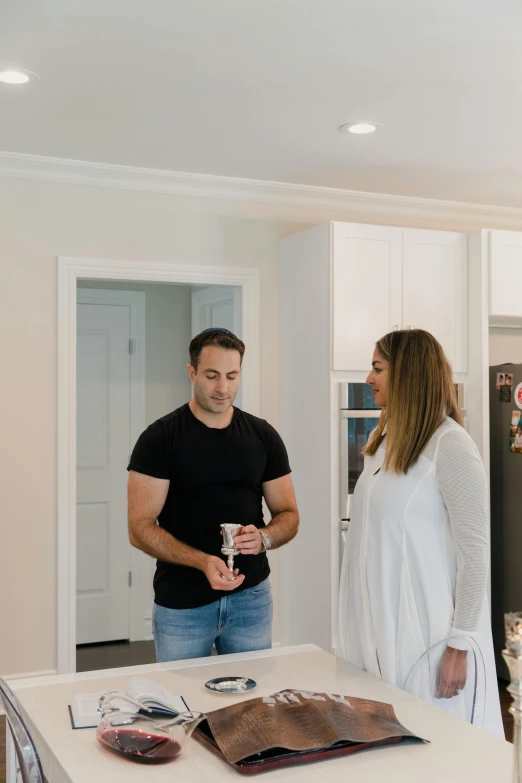 two people standing in a kitchen near the table