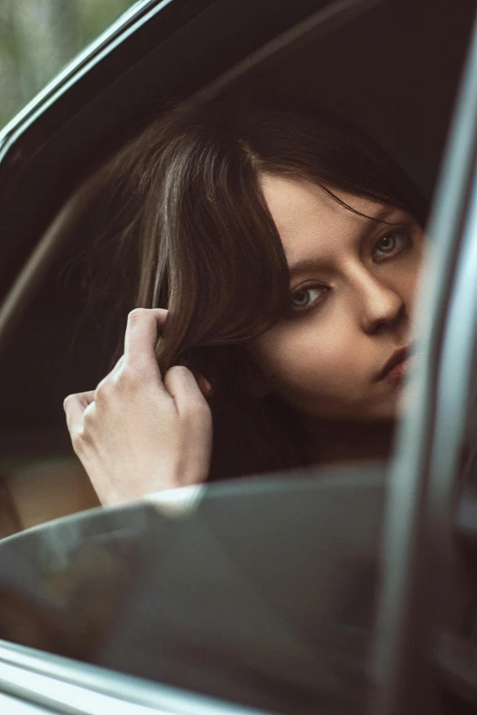 a woman is in a car holding her hand up