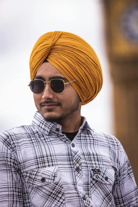 a young man wearing a yellow turban and sunglasses