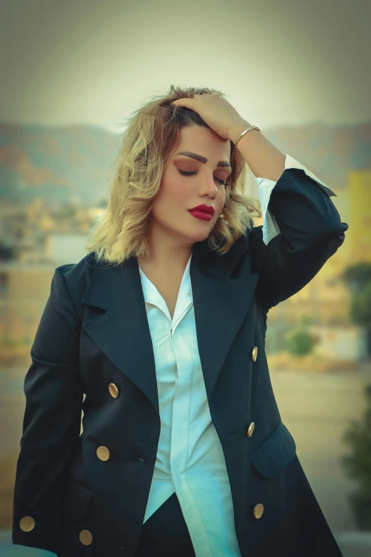 a woman in a green jacket standing with her hands to her ears