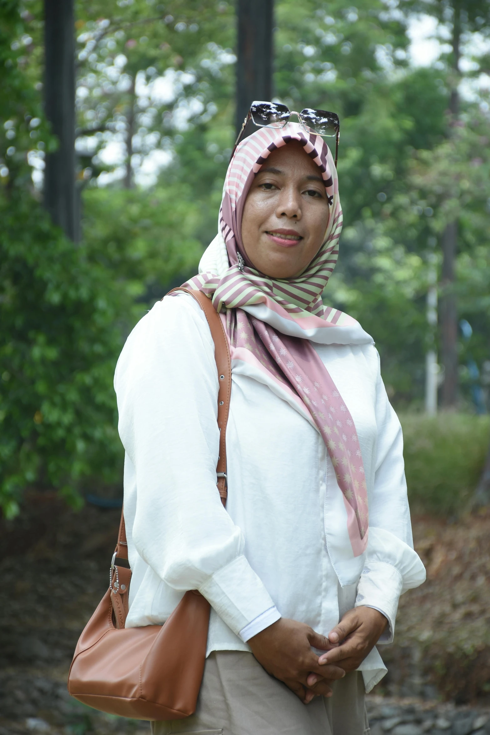 a woman in a headscarf is standing outside