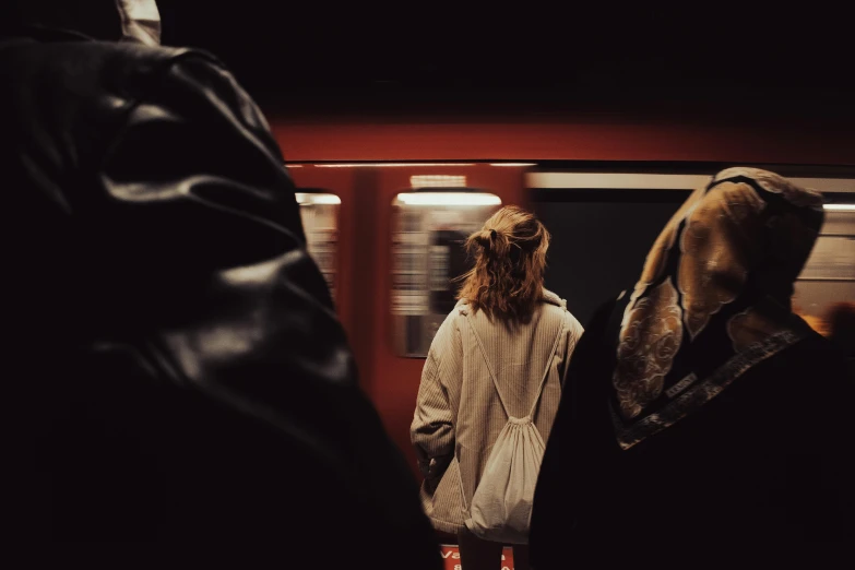 a woman standing in a tunnel waiting on the train