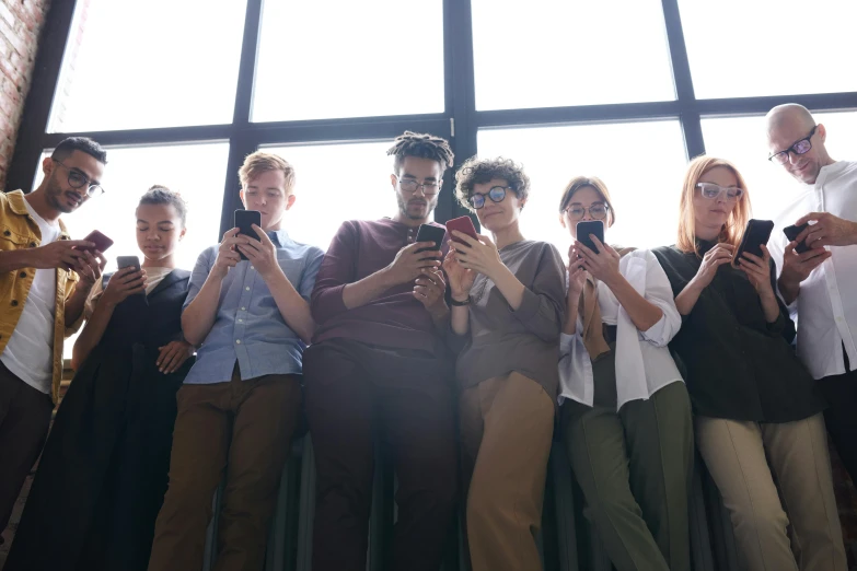 a group of people taking pictures with their cell phones