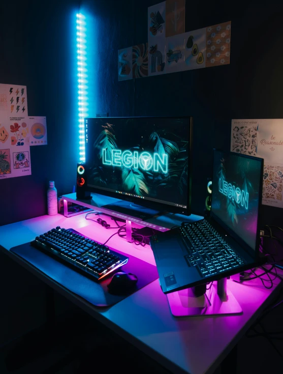 a desk with two monitors and keyboard with neon lights