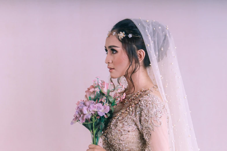 a woman is wearing a veil and holding flowers