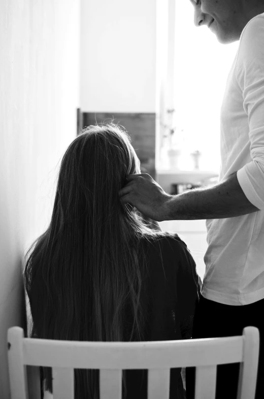 black and white image of two people being hairdryed