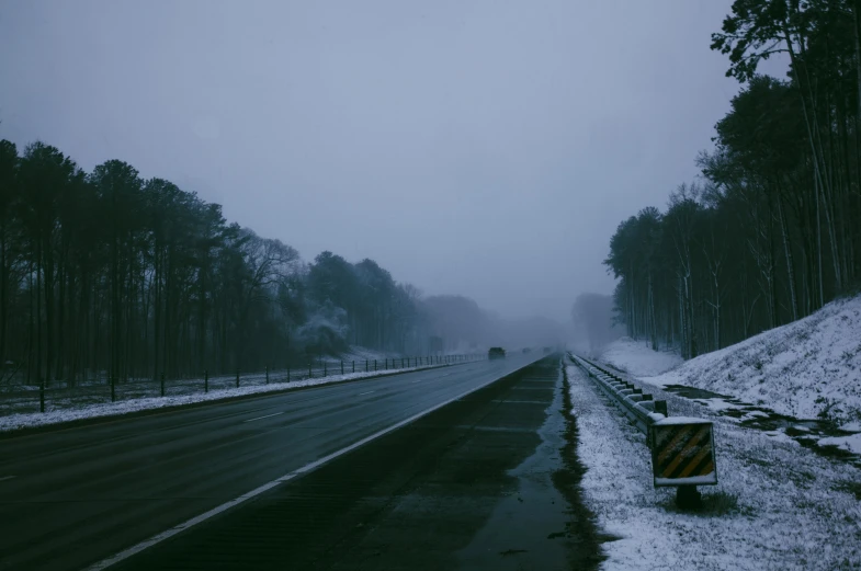 a truck driving on a highway covered in snow