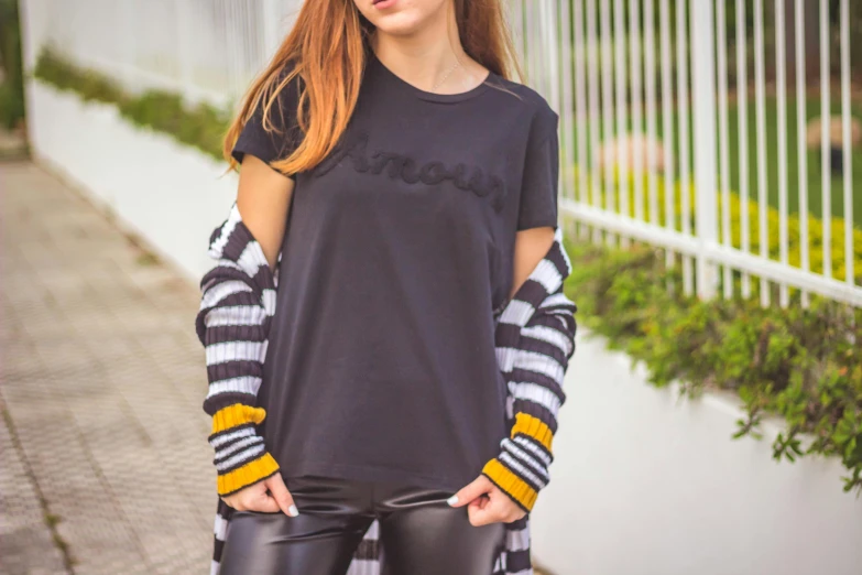 a woman wearing black clothing and leather pants posing