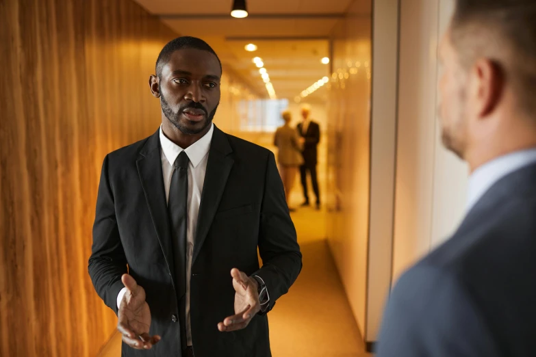 an african american man is talking to a man in suit