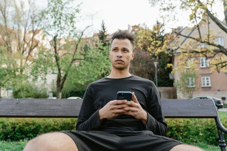 a man sitting on top of a wooden bench