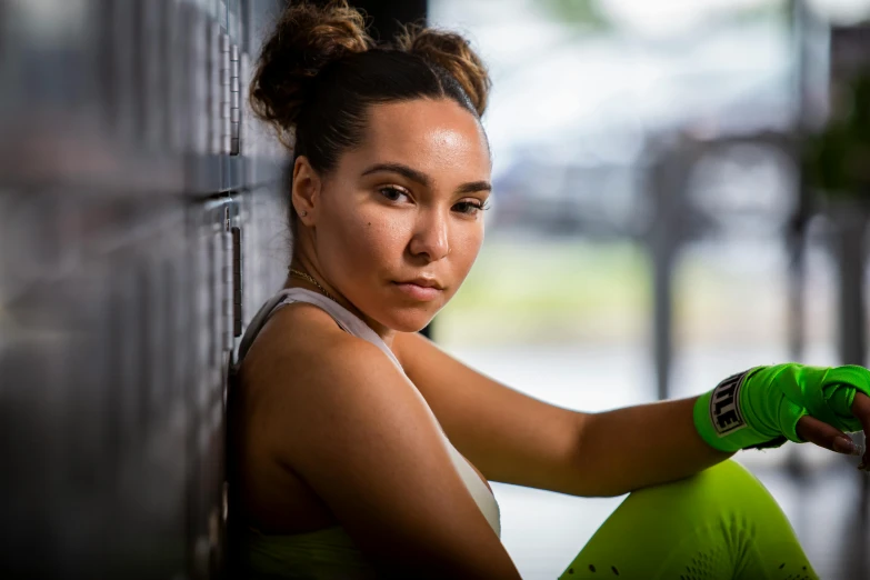 a young woman with green gloves is sitting down