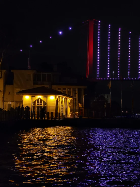 a pier is lit up with purple lights