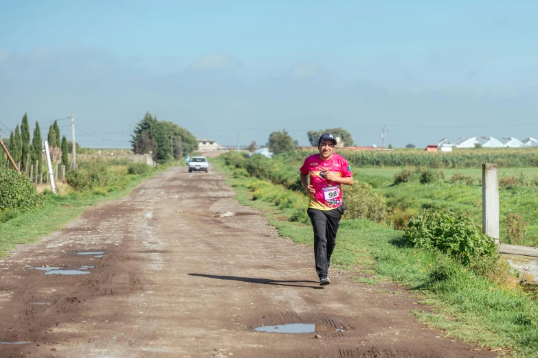 a person is running down the dirt road