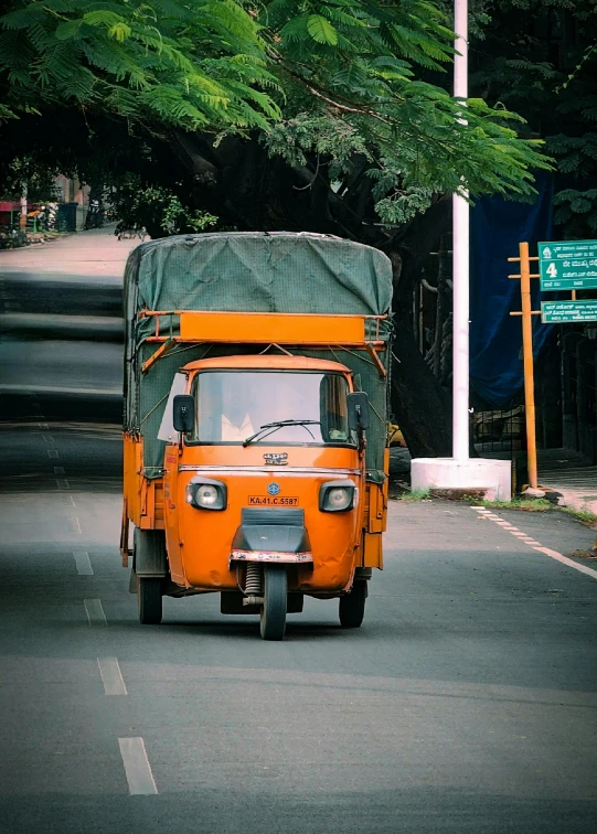 a large orange and green truck on the road