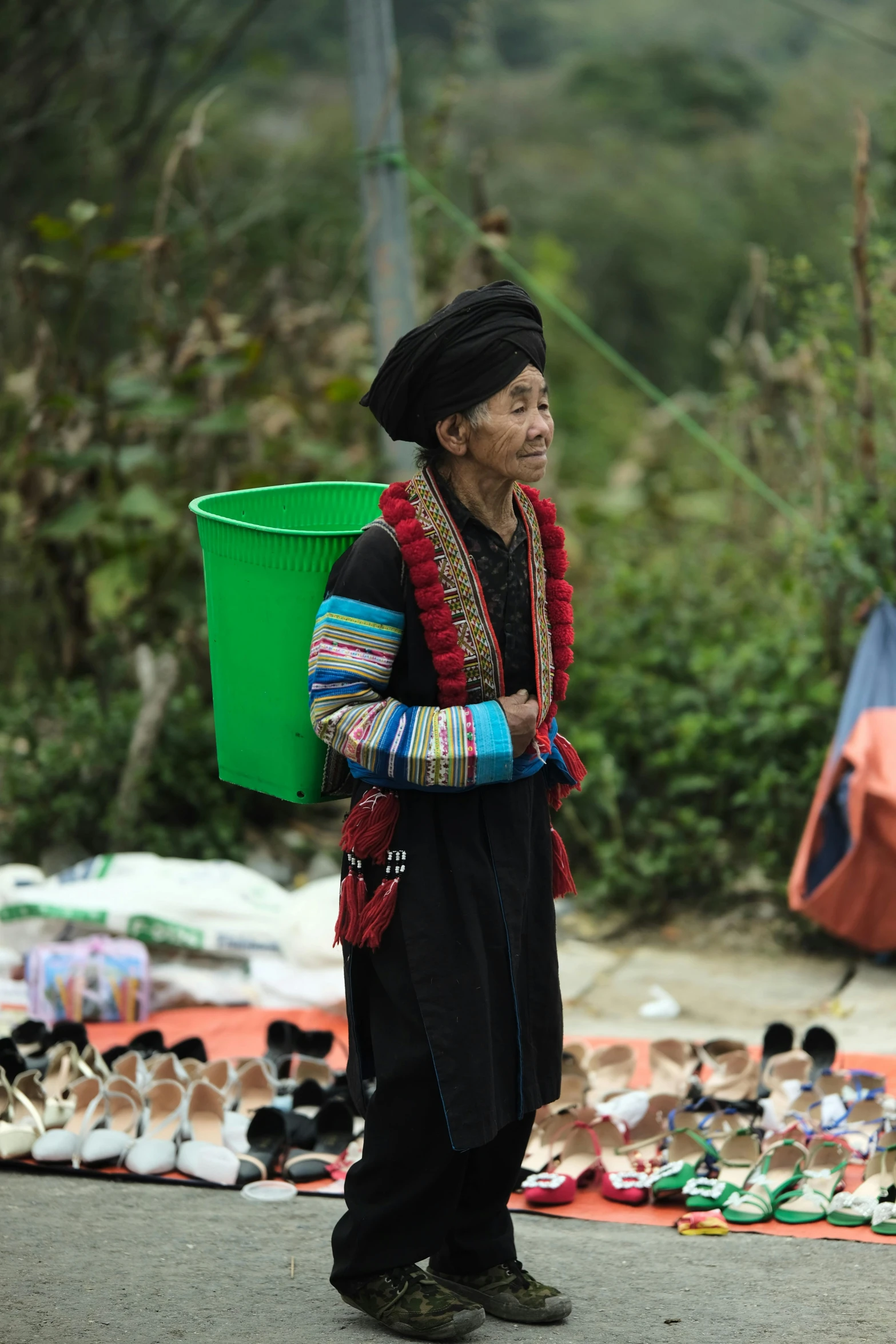 a woman carrying a bucket and a bucket of shoes