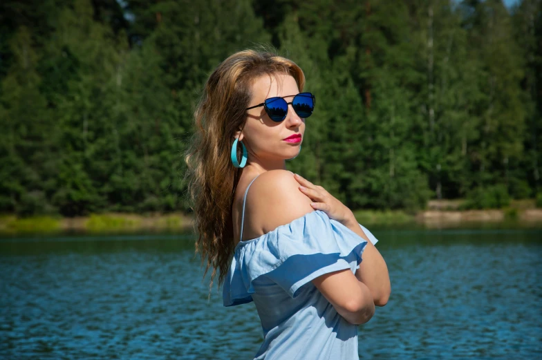 a beautiful young lady standing near the water