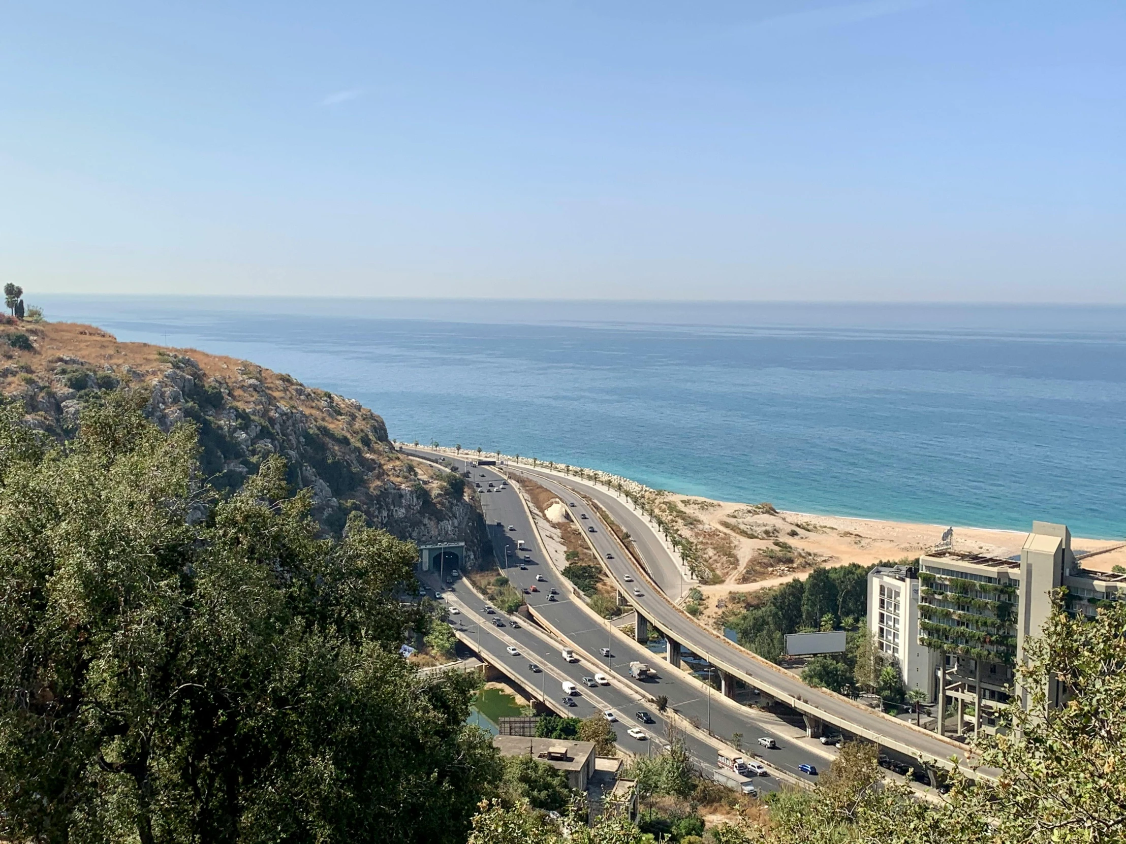 the view of a beach next to some sand dunes and a large body of water