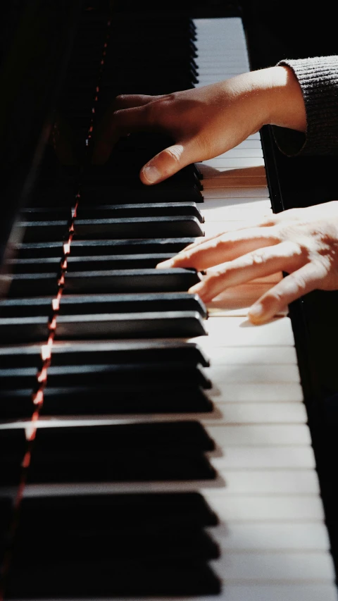 two hands are playing an instrument in the dark