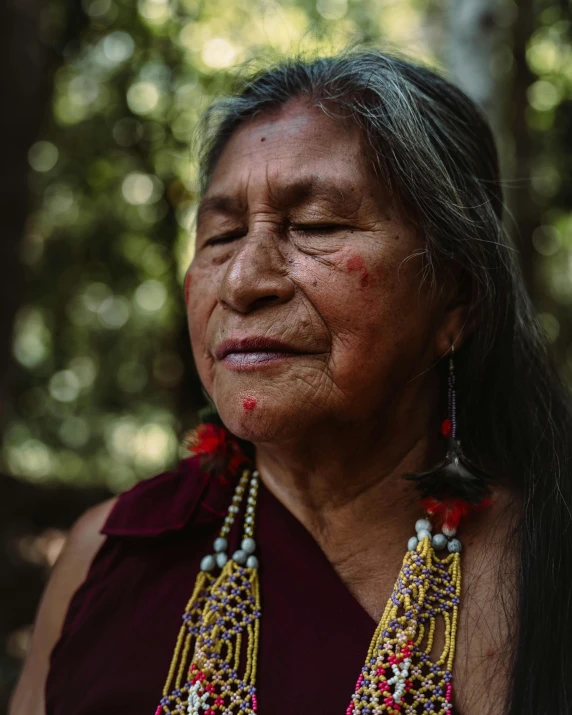 a woman with beaded earrings and a long necklace