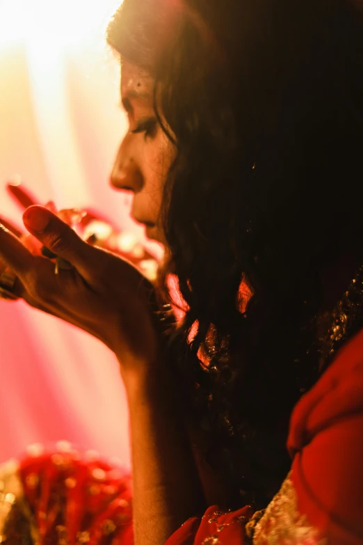 a woman with a red veil and her hands together