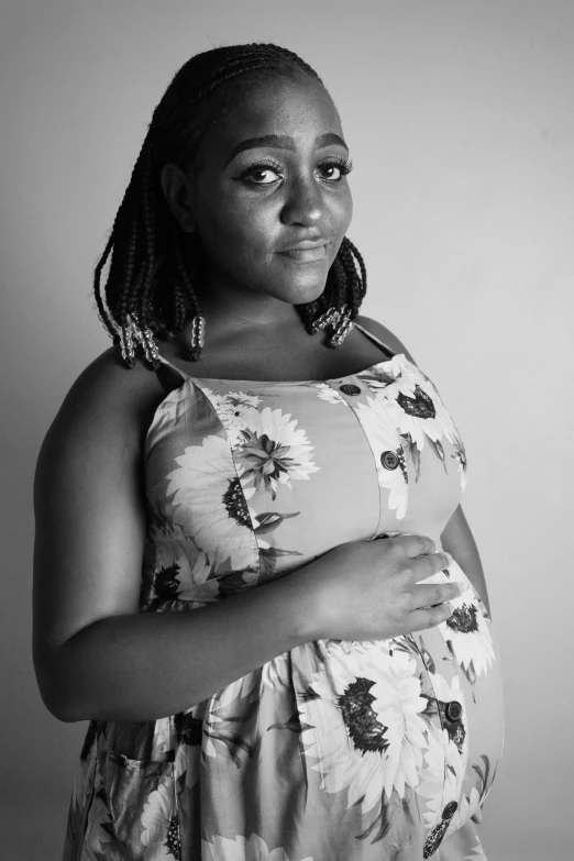 black and white portrait of pregnant woman wearing an over sized sunflower print dress