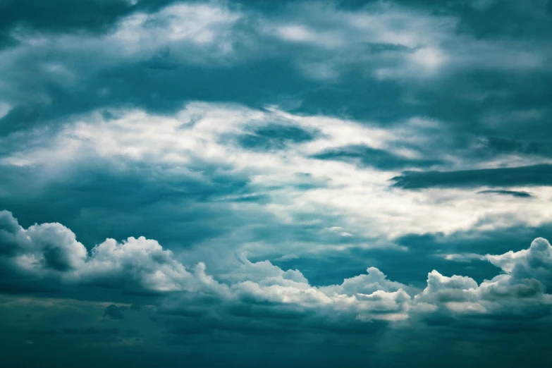 clouds are scattered in the blue sky and on the green of day