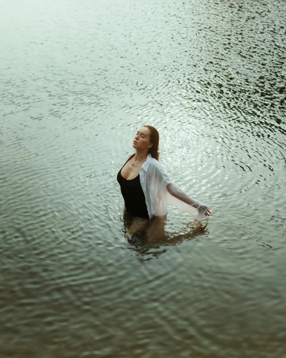 a woman laying down in the water with her arms on her stomach