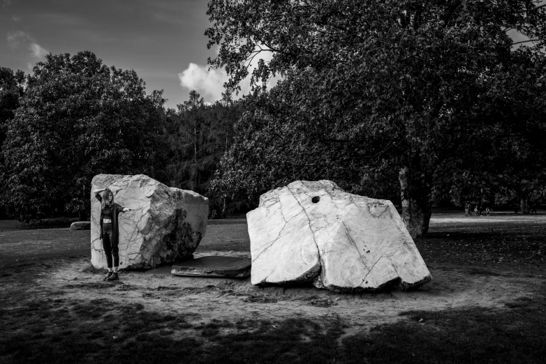 two large rocks on the ground with one person looking up