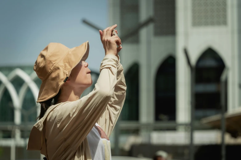 a woman wearing a hat that is reaching up