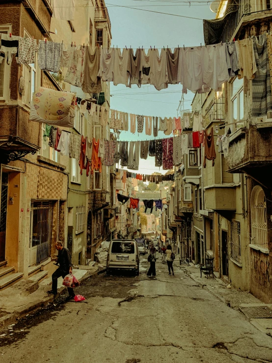 a narrow street with flags hanging over it